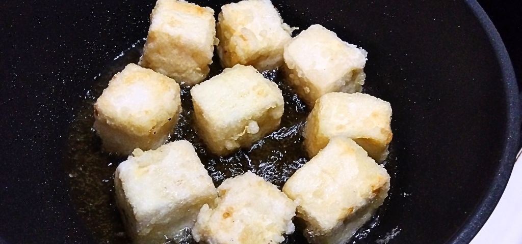 片栗粉をまぶした豆腐を揚げています