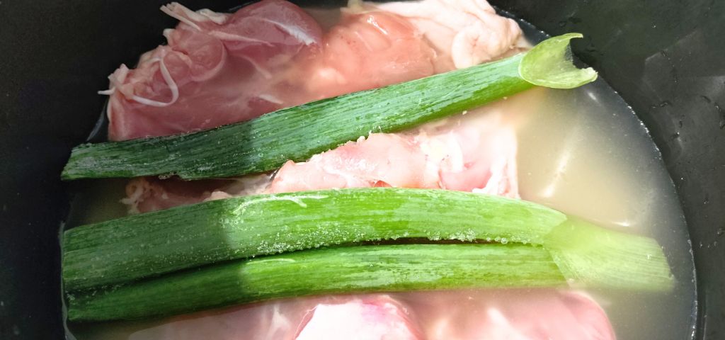 炊飯器に鶏肉とネギの青い部分を入れました