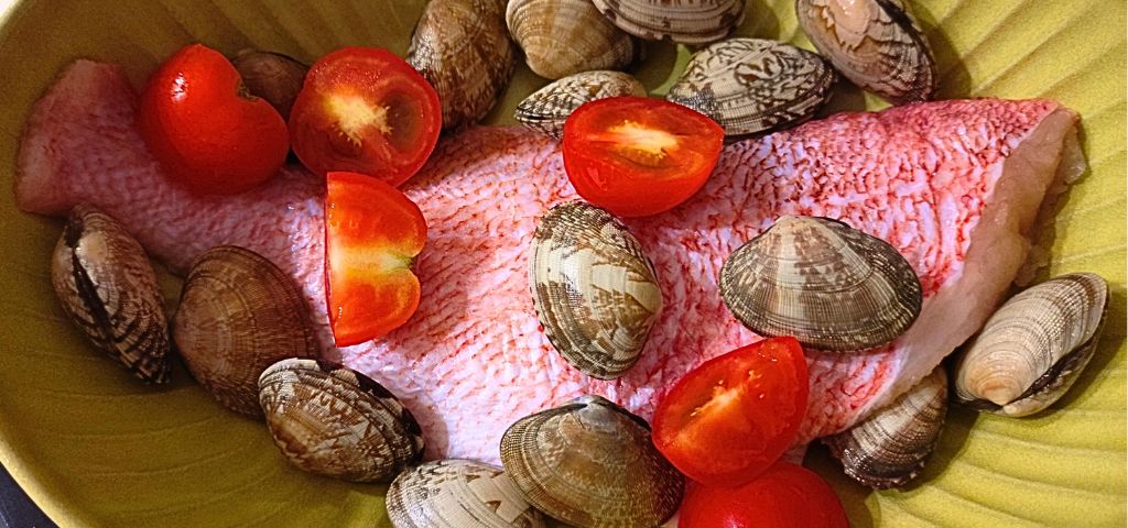 あさりと赤魚、トマトにアクアパッツアの調味料を回しかけます