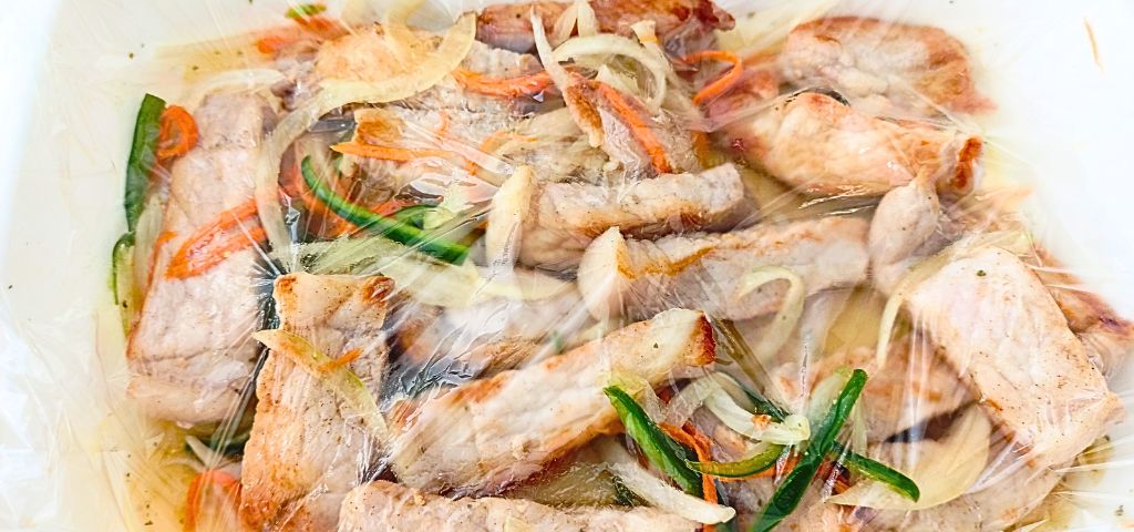 焼いた豚肉をマリネ液に漬けています