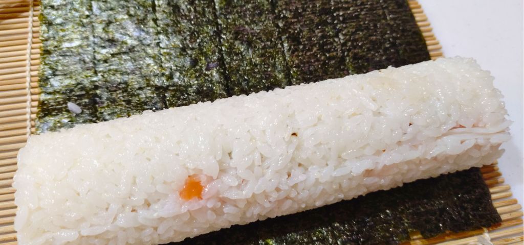 巻き寿司型から外した寿司を海苔に巻きます