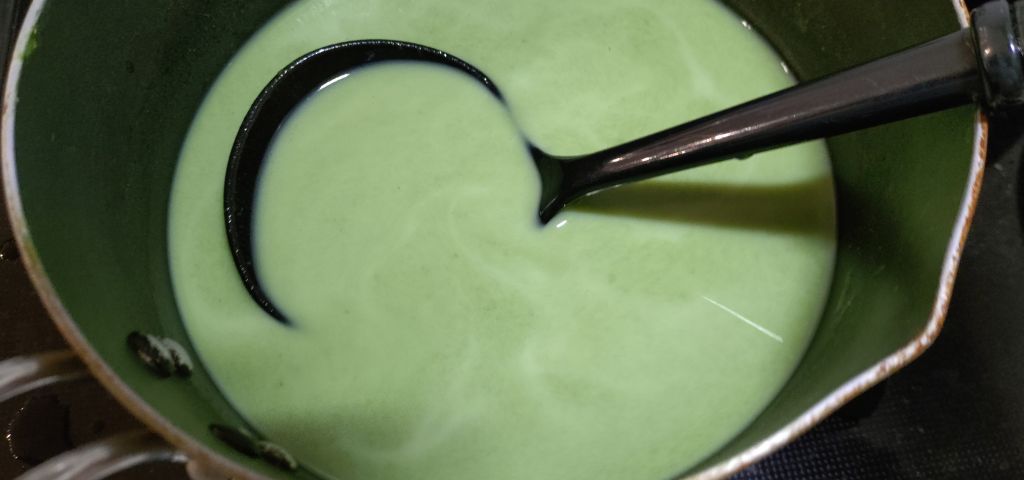 裏ごしした菜の花と牛乳を加熱しています